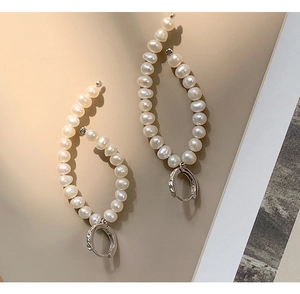 Macro shot of elegant S925 sterling silver hoop earrings with white baroque pearls