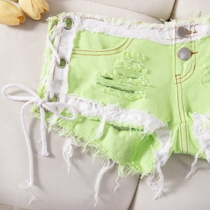 Detalle de shorts vaqueros verde lima con cordones laterales y ojales metálicos