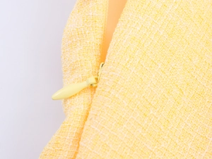 Vista dettagliata della cerniera invisibile su tessuto in tweed giallo operato