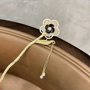 Macro detail of vintage gold hair stick with pearl flowers and dangling tassel charms