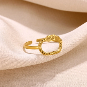 Detail of a 18k gold plated open ring with an oval geometric design on beige fabric