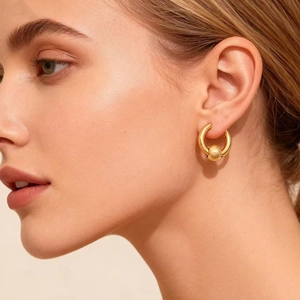 Minimalist gold titanium steel cross ball earrings worn elegantly on a female model