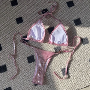 Metallic pink bikini set featuring halter neck top and thong bottom with pearl accents