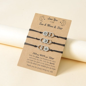 Detailed view of sun, moon, and star charms on woven adjustable cord bracelets