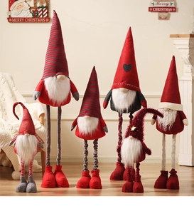 Group of Christmas gnomes in various sizes and colors arranged on a wooden floor