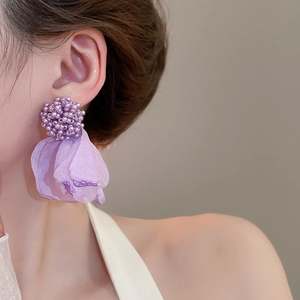 Macro shot of purple beaded flower earrings with organza fabric petals on model