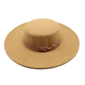 Close-up of a camel flat top wool boater hat with matching ribbon bow decoration