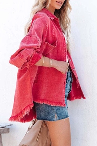 Detailed macro view of the raw hemline and fringe texture on this pink denim jacket