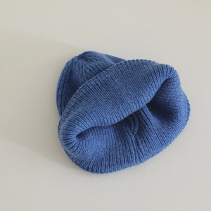 Close-up of deep blue ribbed knit texture and rolled edge detail on a kids' beanie