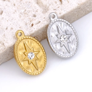 Oval gold and silver star pendants with sparkling crystals on beige stone base
