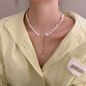 Detail view of irregular baroque pearl heart pendant necklace with gold chain link