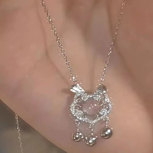 Dettaglio di una collana con ciondolo a gatto in argento con piccoli campanellini