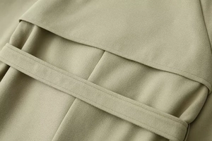 Detailed macro view of olive green wool jacket showing premium twill fabric and stitching