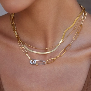 Layered gold paperclip necklace with herringbone chain and silver pin clasp detail