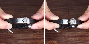 Detail of black braided leather bracelet showing the silver magnetic clasp open and closed