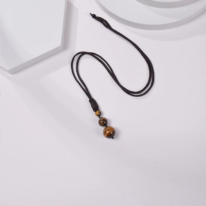 Detail of 16mm tiger eye stone pendant with adjustable deep brown braided rope necklace
