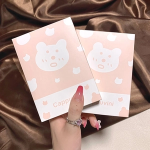 Close-up of pink lip glaze gift set with cute bear design on luxury brown silk fabric