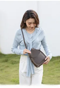 Detail of vintage brown crossbody phone bag with classic floral pattern on outer flap