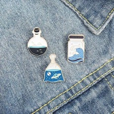 Detailed set of three creative enamel pins featuring artistic wave and galaxy patterns