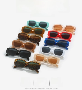 Flat lay of retro square sunglasses in multiple vibrant colors on white background