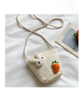 Dettaglio della borsa in paglia color crema per bambini con coniglietto e carota