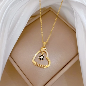Détail du collier cœur de football en titane doré avec cristaux et breloque en émail noir