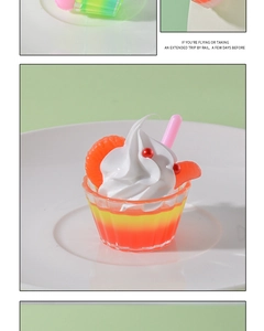 Close-up of a mini realistic fruit sundae cup with cream topping and orange slices