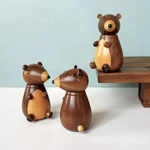 Detailed view of three handcrafted wooden bear salt and pepper grinders in walnut finish