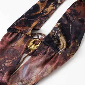 Detail of mesh printed fabric with gold metal O-ring buckle on a backless dress