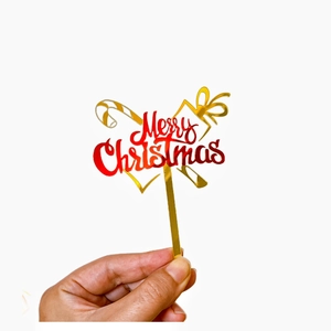 Golden acrylic Merry Christmas cake topper with red lettering and festive gift accents