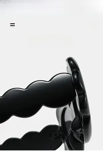 Detailed macro view of the black wavy texture on lightweight oval sunglasses frames