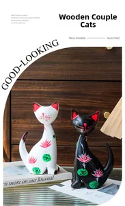 Detail of hand-painted wooden cat figurines with floral folk art patterns in a cozy room