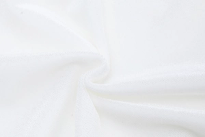 Gros plan sur la texture du tissu tricoté blanc montrant les fibres et les plis doux