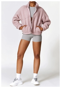 Detailansicht der rosa Fleecejacke mit Stehkragen, Reißverschluss und großen Taschen