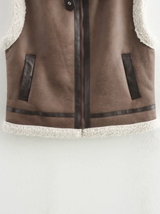 Detailed macro shot of brown faux suede vest with soft cream shearling lining and stitching