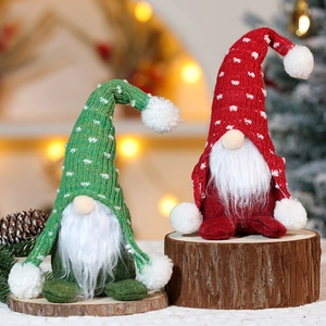 Dettaglio di gnomi di Natale in maglia rossi e verdi su base in legno con luci festive