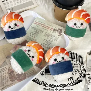 Detail of cute salmon sushi plush keychains with blue and green bands on white tray