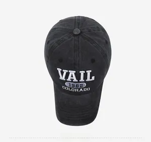 Macro detail of high-quality embroidery with VAIL text on washed dark gray denim baseball cap