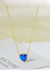 Close-up of blue heart crystal pendant on a gold titanium steel necklace