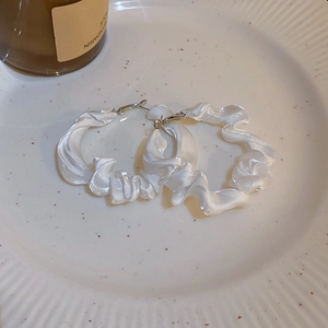 Detail of white pleated satin fabric wrapped around large hoop earrings with S925 silver needles