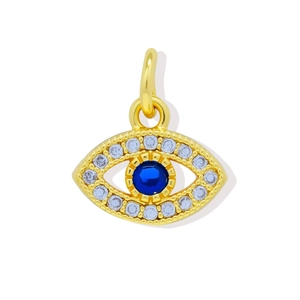 Macro shot of 18K gold plated evil eye pendant with blue gem and zircon inlay