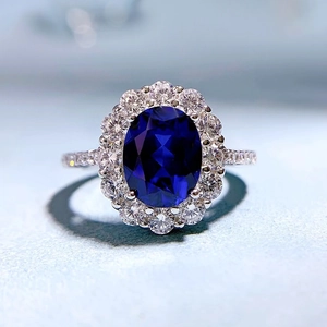 Elegant halo ring with oval sapphire blue stone and pave set clear zircon accents