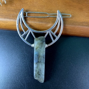 Detail of silver crescent moon hair clip with a raw labradorite stone pendant