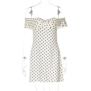Close-up of strapless white dress with black polka dots featuring chest knot and ruffles