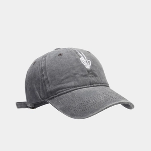 Detailed embroidery of a skeleton hand on a washed charcoal grey vintage baseball cap