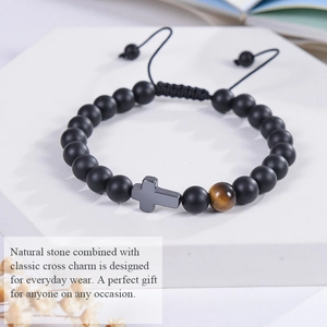 Macro shot of 8mm matte black stone beads bracelet with a cross pendant on a white stand