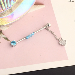 Detail of surgical steel industrial barbell with blue zircon and crystal heart pendant