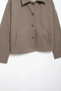 Detailed view of the buttoned lapel and textured brown wool fabric on a casual short jacket