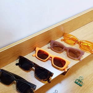 Detailed close-up of colorful rectangle sunglasses displayed on a wooden surface
