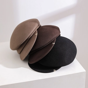 Three stylish wool newsboy hats in brown, chocolate, and black on a white pedestal.